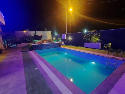 a swimming pool at night with lights at The Oaks in Madaba