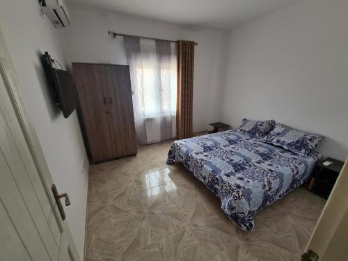 een slaapkamer met een bed met een blauw dekbed bij Cité 200 logement mimouni borj el Kiffan alger in Fort de lʼEau