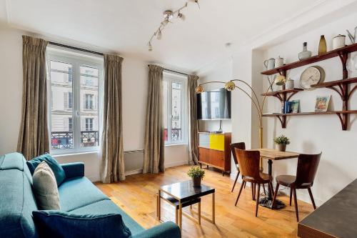 un soggiorno con divano blu e tavolo di Nice apartment in the 6th arr of Paris - Welkeys a Parigi