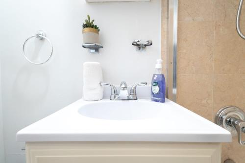La salle de bains est pourvue d'un lavabo blanc et d'une douche. dans l'établissement 350-GA Spacious Studio Gramercy Sleeps3, à New York