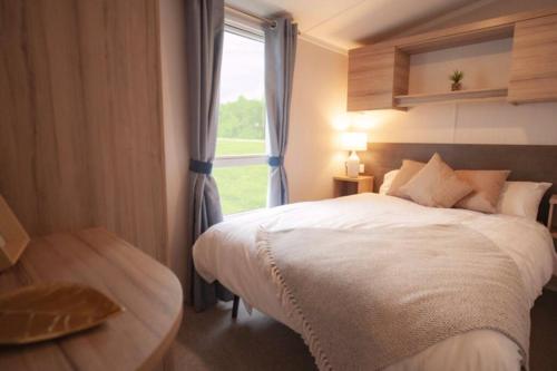 Un dormitorio con una cama grande y una ventana en Sandylands Holiday Home, en Stevenston