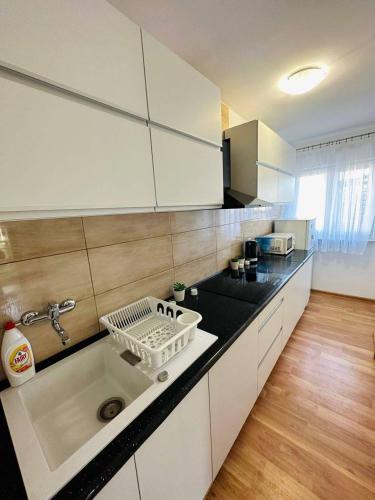 a kitchen with a sink with a dish rack on it at City View Rooms in Warsaw