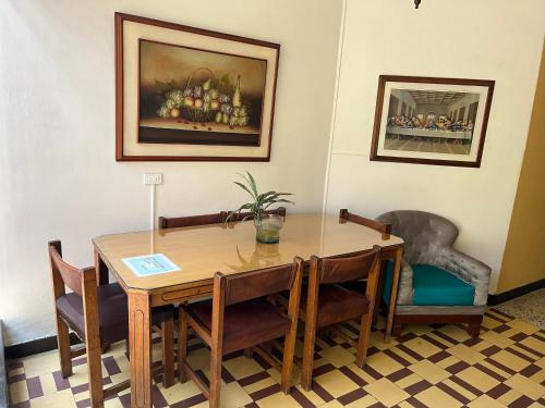 Casa Grande Hostal في ميديلين: غرفة طعام مع طاولة وكراسي