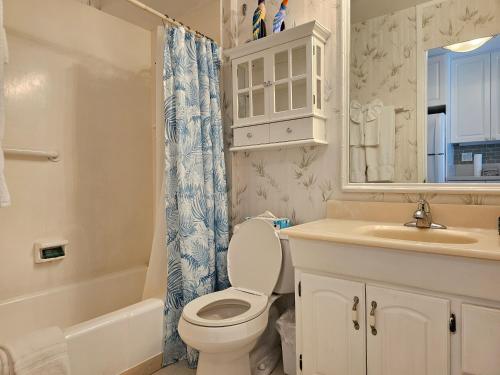 een badkamer met een toilet, een wastafel en een spiegel bij Ilikai Marina 987 City View Studio in Honolulu