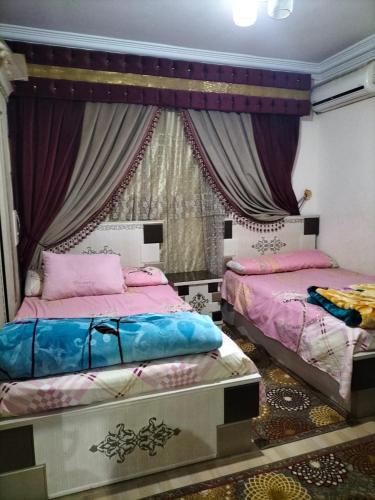 1 dormitorio con 2 camas y ventana en شقة ايجار مفروش 4 نوم 3 حمام 4 ريسيبشن, en El Cairo