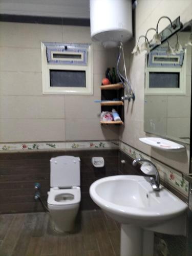 a bathroom with a sink and a toilet and a mirror at شقة ايجار مفروش 4 نوم 3 حمام 4 ريسيبشن in Cairo