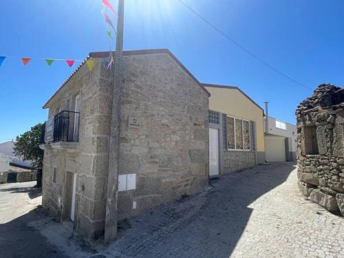 a stone building with flags on the side of it at Casa rural Safurdão in Safurdão