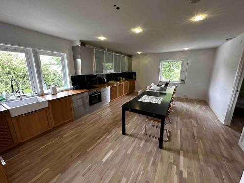 a large kitchen with a table in the middle of it at Villa Trollbäcken med bastu, värmegolv, öppen spis in Tyresö