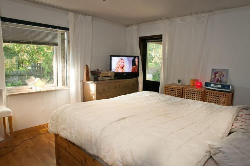 a bedroom with a large bed and a television at Villa Livslust Trollbäcken uthyrning pågår in Tyresö