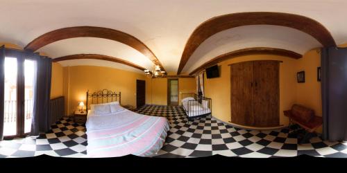 a bedroom with a bed and a checkered floor at Casa Rural Garrido in Ademuz