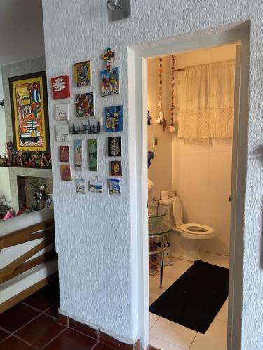 a bathroom with a toilet and a wall with pictures at Mini casa en el mirador San Bernardino. Guarania in San Bernardino