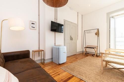 a living room with a couch and a television at Amália Boutique Suites & Studios - by @ rita´s place in Faro