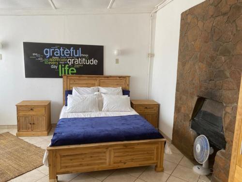 1 dormitorio con 1 cama y chimenea en Kappsfarm Guesthouse en Voigtland