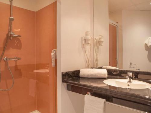 uma casa de banho com um lavatório e um chuveiro em The Originals City, Plume Hôtel, Bressuire (Inter-Hotel) em Bressuire