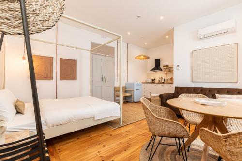 a bedroom with a bed and a table and chairs at Amália Boutique Suites & Studios - by @ rita´s place in Faro