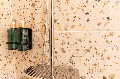 a bathroom with a mirror and a wall with confetti at Amália Boutique Suites & Studios - by @ rita´s place in Faro