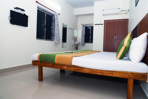 a bedroom with a wooden bed in a room at Royal Green - Airport Stay in Chennai