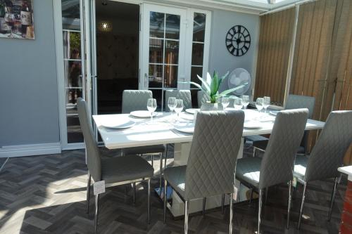 a white dining room with a white table and chairs at Largee 5 Bed House, Sleeps 10 Near NEC, BHX, HS2 in Birmingham