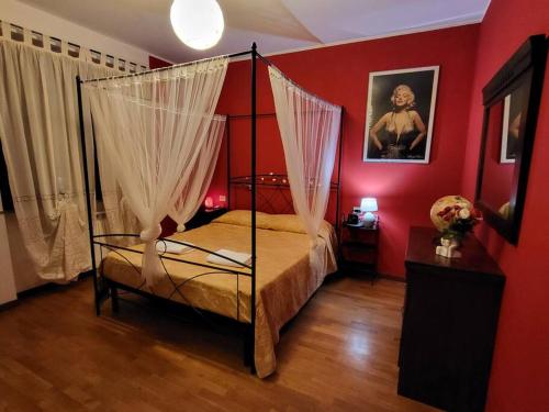 a bedroom with a canopy bed in a red room at Home Sweet Home in Bareggio