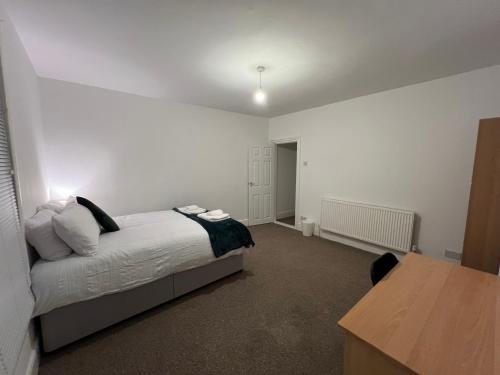 um quarto com uma cama e uma mesa em The Coral Guest House 1 Fratton Park Portsmouth em Portsmouth