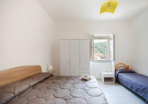 ein Schlafzimmer mit einem großen Bett und einem Fenster in der Unterkunft Casa Vacanze Nonna Rosaria al centro di Ascea Marina in Ascea