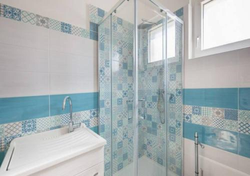 ein Bad mit einer Glasdusche und einem Waschbecken in der Unterkunft Casa Vacanze Nonna Rosaria al centro di Ascea Marina in Ascea