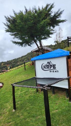 a sign with a tree on top of a field at Carpe Diem in Guatavita
