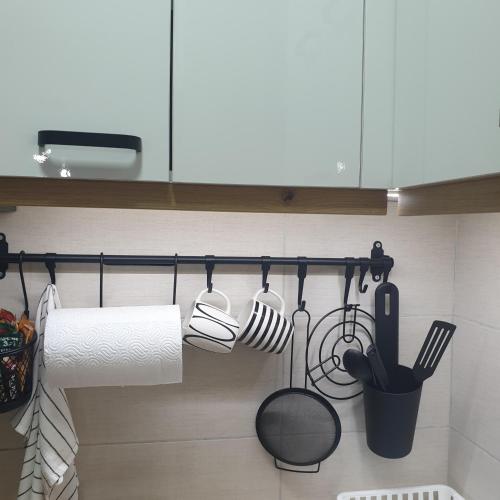 a kitchen with utensils hanging on a wall at Apartman Dunjic in Vrnjačka Banja
