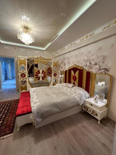 a bedroom with a large bed and a chandelier at Apartment Vefa Center in Dushanbe