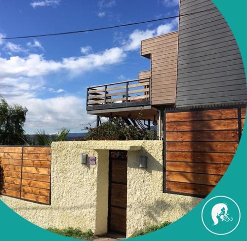 a house with a wooden door and a fence at Yemanya Hostal in Concón