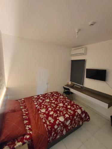 a bedroom with a bed and a flat screen tv at RDTROOM At Aeropolis in Teko