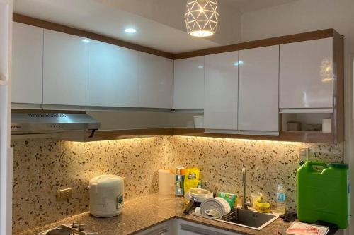 a kitchen counter with white cabinets and a sink at Mid-rise Condo in Antipolo by Casa Akiolo in Antipolo