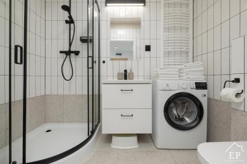 une salle de bain avec douche et machine à laver dans l'établissement Apartament MARE 13 Marina Dziwnów & SPA Basen EPapartamenty, à Dziwnów