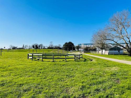a park with benches in the grass next to a path at ARZON TERRASSE DE KERJOUANNO in Arzon