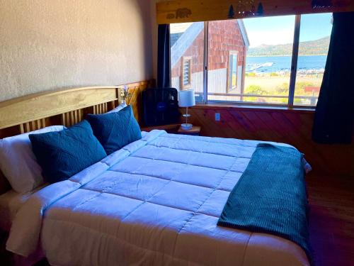 a bedroom with a large bed with a large window at Lakefront Escape in Big Bear Lake