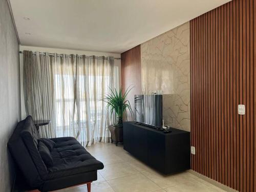 a living room with a couch and a television at Apartamento na Praia do Francês in Marechal Deodoro