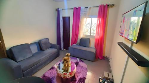 ein Wohnzimmer mit einem Sofa und einem Tisch in der Unterkunft LNIMMO - DEPOU - Studio meublé Ahmadou Ekie climatisé et avec internet illimité avec forage in Jaunde