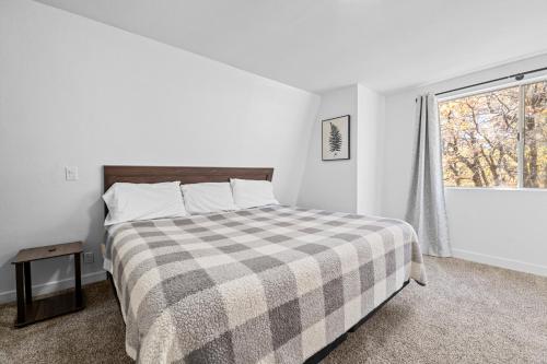 a white bedroom with a bed and a window at Sugarwood -Cozy and relaxing cabin that sits on a tranquil lot! Ping pong and Air Hockey Table! in Sugarloaf