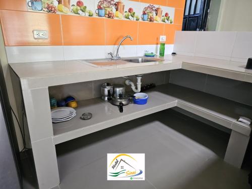 a kitchen with a sink and a counter top at Hostal Sinaí in Mocoa