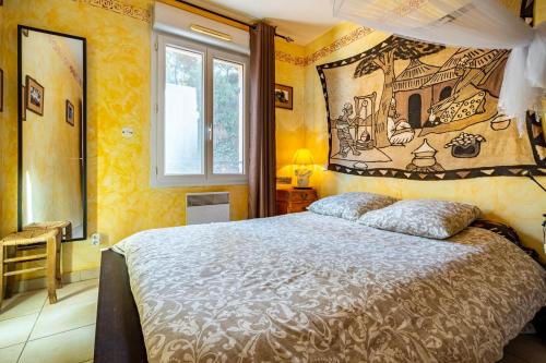 - une chambre avec un lit orné d'une peinture murale dans l'établissement Villa Calanques, à Ensuès-la-Redonne