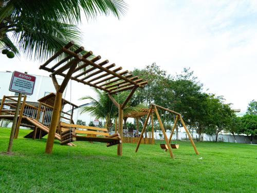 a playground with a wooden swing and a swing at Hotel BHS in Linhares