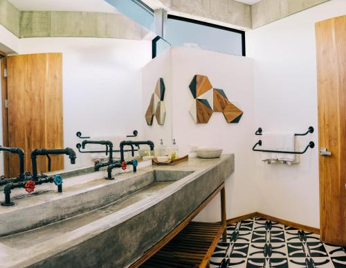 a bathroom with two sinks and a window at Puro Surf Hotel & Performance Academy in El Zonte