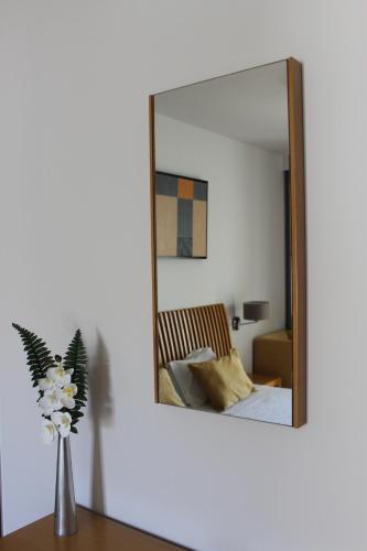 a mirror on a wall next to a bedroom at Hotel Paulo VI in Rio Maior