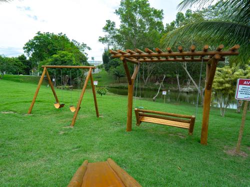 a park with two swings and a bench and a swing istg at Hotel BHS in Linhares