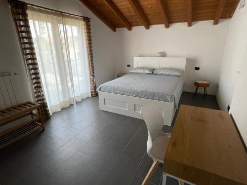 um quarto com uma cama branca, uma mesa e uma mesa; em Appartamento Cavaria 416 em Cavaria