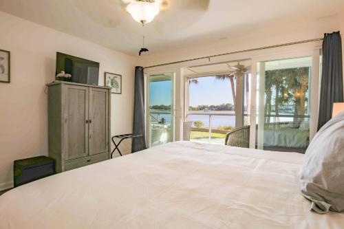 um quarto com uma grande cama branca e uma janela em Serenity em Folly Beach