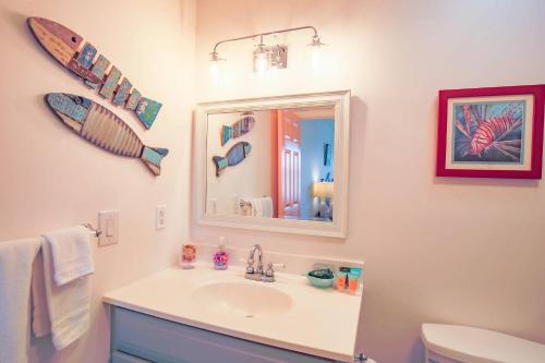 uma casa de banho com um lavatório e um espelho em Serenity em Folly Beach