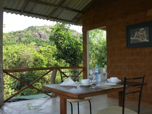 a table with chairs and a view of a mountain at The Thick Forest in Sigiriya