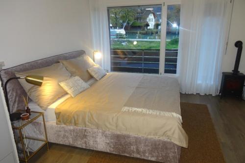 a bed in a room with a large window at Aare Studio 2 in Interlaken