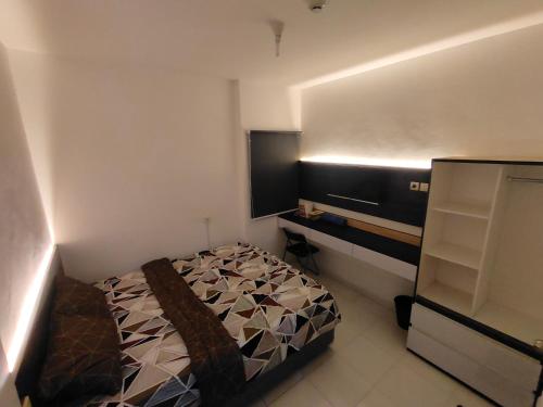 Teko的住宿－RDTROOM TRANSIT At Aeropolis，一间小卧室,配有一张床和电视